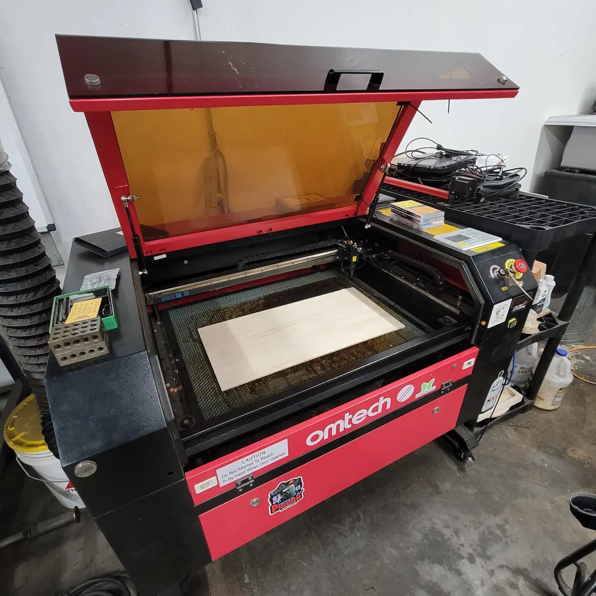 The OMTech 60W CO2 laser cutter with its lid open at the Tarrant County Makerspace